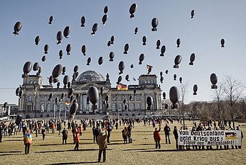 Aktive lassen vor dem Berliner Reichstag 100 Ballons in Form von Bomben steigen